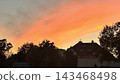 Red Sunset Sky Over Houses in a Small Town or Village 143468498