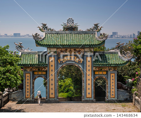 Woman in conical hat walking through Tam Quan Gate at Linh Ung Pagoda in Da Nang, Vietnam Woman in conical hat walking through Tam Quan Gate at Linh Ung Pagoda in Da Nang, Vietnam 143468634