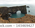 Volcanic rock arch at Dyrholaey peninsula over the ocean, Iceland 143469427