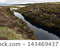 Glacial water filling a rocky volcanic fissure in a mossy rift valley, Iceland 143469437