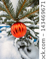 Christmas tree is adorned with ornaments while surrounded by fresh snow. The scene captures the spirit of winter festivities in a joyful setting 143469671