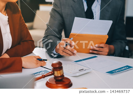 Businessmen or lawyers working together at a meeting, teamwork and partnership. Signing documents, contracts, checking details business agreement Businessmen or lawyers working together at a meeting, teamwork and partnership. Signing documents, contracts, checking details business agreement 143469737
