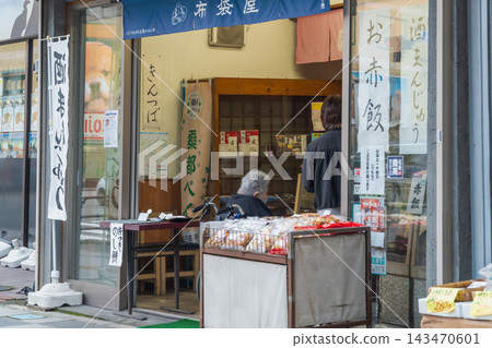 一位坐在輪椅上的母親帶著女兒來到日式點心店。 一位坐在輪椅上的母親帶著女兒來到日式點心店。 143470601