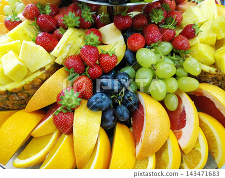 assorted ripe fruits and berries on a white plate 143471683