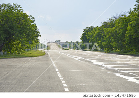 The asphalt road goes into the distance and ends with an ascent to a bridge The asphalt road goes into the distance and ends with an ascent to a bridge 143471686