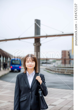 一位年輕的女商人站在城市裡 一位年輕的女商人站在城市裡 143472137