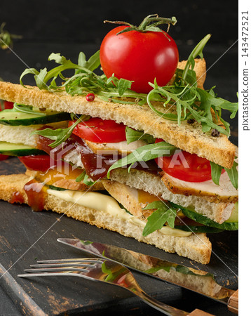Grilled chicken sandwich with fresh tomatoes, cucumbers, arugula Grilled chicken sandwich with fresh tomatoes, cucumbers, arugula 143472521