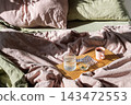 Medication and Water on Tray in Bed with Soft Sunlight 143472553