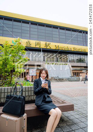 一位女商人坐在火車站的長椅上。 143472858