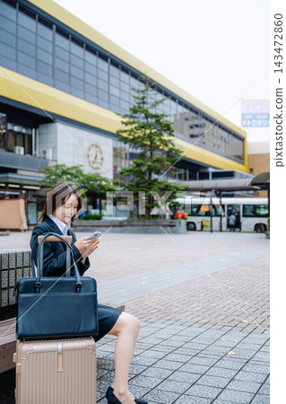 一位女商人坐在火車站的長椅上。 一位女商人坐在火車站的長椅上。 143472860
