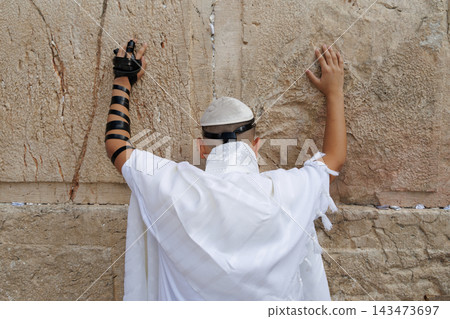 Jewish teenager praying at the Western wall in Jerusalem Jewish teenager praying at the Western wall in Jerusalem 143473697
