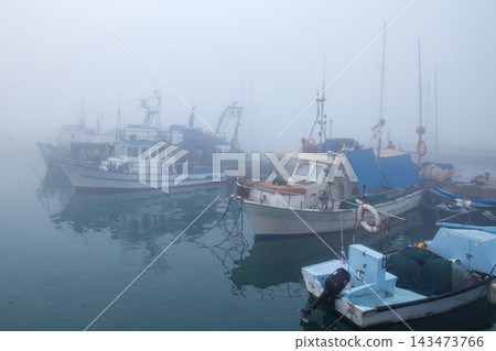 Fishing boats in the foggy harbor of Jaffa port. Israel Fishing boats in the foggy harbor of Jaffa port. Israel 143473766