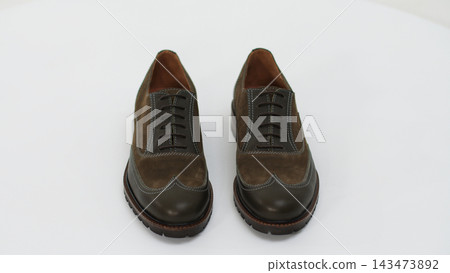 Pair of brown suede and leather oxford wingtip shoes with laces, offering classic men's fashion footwear style Pair of brown suede and leather oxford wingtip shoes with laces, offering classic men's fashion footwear style 143473892