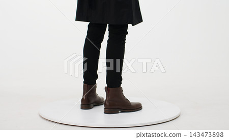Man wearing fashionable brown leather boots and black trousers, showcasing autumn and winter footwear fashion Man wearing fashionable brown leather boots and black trousers, showcasing autumn and winter footwear fashion 143473898