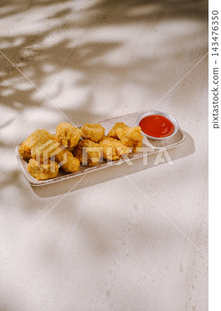 Crispy golden fried nuggets with ketchup sauce on plate Crispy golden fried nuggets with ketchup sauce on plate 143476350