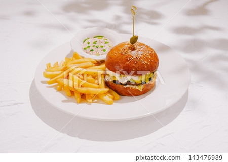 Gourmet burger with french fries and dipping sauce on white plate Gourmet burger with french fries and dipping sauce on white plate 143476989