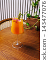 Refreshing orange cocktail with rosemary and dried raspberries 143477076