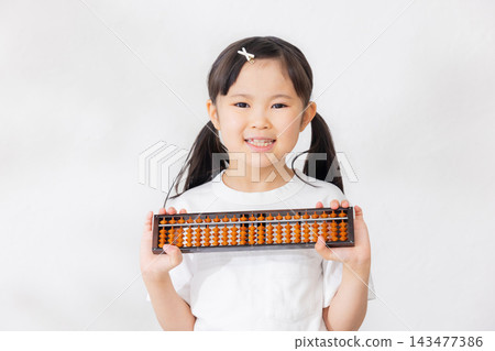一名小學生拿著算盤 一名小學生拿著算盤 143477386