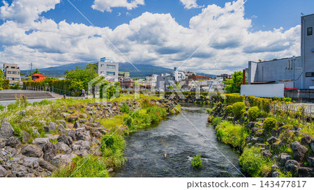 A 16:9 widescreen summer sky view overlooking the clear waters of the Kanda River and the cityscape of Fujinomiya. A 16:9 widescreen summer sky view overlooking the clear waters of the Kanda River and the cityscape of Fujinomiya. 143477817
