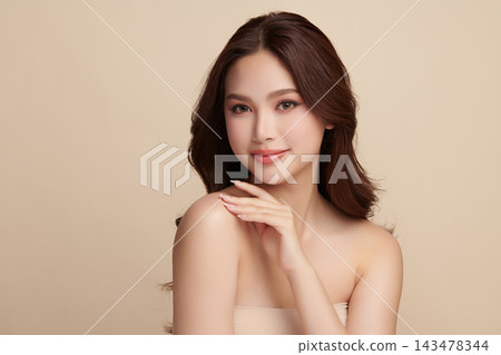 A beautiful young Asian woman with clean, fresh skin against a beige background. Skincare, facial treatment, cosmetology, beauty, and spa. An elegant portrait of an Asian woman. A beautiful young Asian woman with clean, fresh skin against a beige background. Skincare, facial treatment, cosmetology, beauty, and spa. An elegant portrait of an Asian woman. 143478344