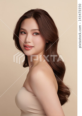 A beautiful young Asian woman with clean, fresh skin against a beige background. Skincare, facial treatment, cosmetology, beauty, and spa. An elegant portrait of an Asian woman. A beautiful young Asian woman with clean, fresh skin against a beige background. Skincare, facial treatment, cosmetology, beauty, and spa. An elegant portrait of an Asian woman. 143478350