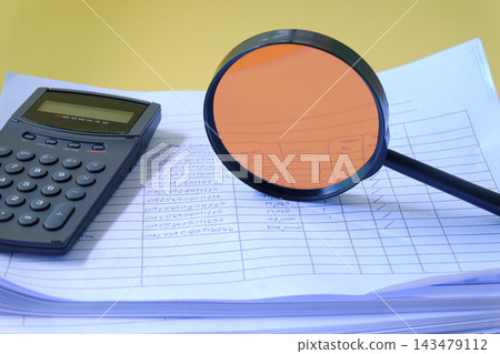 Magnifying glass and calculator on Stack of documents. Magnifying glass and calculator on Stack of documents. 143479112