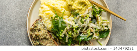 A plate shows a serving of boiled potatoes with hummus, a gluten free bread sandwich filled with herring mince, and fresh salad. This breakfast offers a nutritious start to the day, banner A plate shows a serving of boiled potatoes with hummus, a gluten free bread sandwich filled with herring mince, and fresh salad. This breakfast offers a nutritious start to the day, banner 143479251