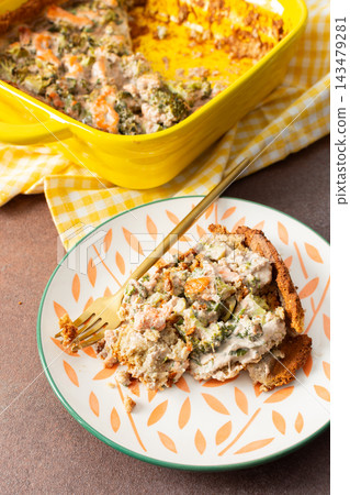 A slice of gluten-free pie sits on a plate beside a fork. The pie is made with red fish and broccoli, perfect for a healthy breakfast or lunch. A cup of tea is nearby in a cozy setting A slice of gluten-free pie sits on a plate beside a fork. The pie is made with red fish and broccoli, perfect for a healthy breakfast or lunch. A cup of tea is nearby in a cozy setting 143479281
