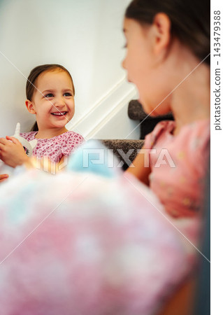Young sisters laughing playing together on stairs at home Young sisters laughing playing together on stairs at home 143479388