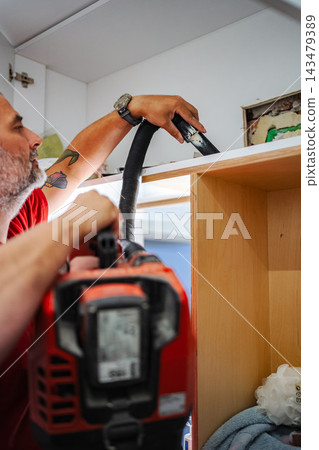 Man vacuuming dust during home renovation Man vacuuming dust during home renovation 143479389