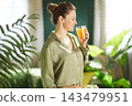 Woman Enjoying Refreshing Orange Juice at Home 143479951