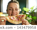 Close-up of Woman Enjoying Comfort Food at Home 143479958
