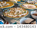 Vietnamese banh beo steamed rice cakes with fried shallots and scallions on bamboo platter at buffet, traditional food display 143480143