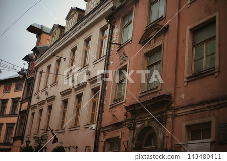 Atmospheric perspective of a historical old town street featuring classical facades with arched. Atmospheric perspective of a historical old town street featuring classical facades with arched. 143480411