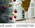 Christmas in Strasbourg, Alsace, France. Red and golden Christmas baubles hanging on a frosted fir tree. 143480746