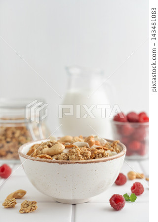 Muesli with fresh raspberries and nuts in a bowl, close-up Muesli with fresh raspberries and nuts in a bowl, close-up 143481083