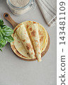 Stack of lavash or chapati flatbreads on a wooden cutting board 143481109