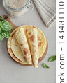 Stack of lavash or chapati flatbreads on a wooden cutting board 143481110