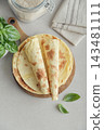Stack of lavash or chapati flatbreads on a wooden cutting board 143481111