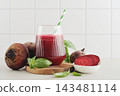 Beetroot juice in a glass with a striped paper straw, served with raw beetroot and fresh basil 143481114