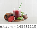 Beetroot juice in a glass with a striped paper straw, served with raw beetroot and fresh basil 143481115