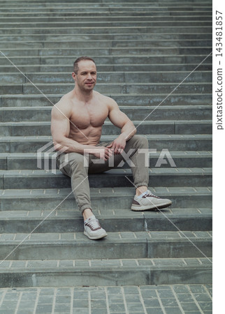 A CrossFit man poses for the camera on a sports A CrossFit man poses for the camera on a sports 143481857