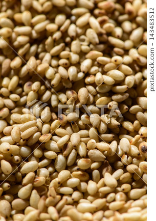 A background image featuring plenty of roasted white sesame seeds, creating a fragrant and aromatic food. A background image featuring plenty of roasted white sesame seeds, creating a fragrant and aromatic food. 143483512