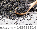 Black sesame seeds on a wooden spoon and fragrant ingredients spread on a white background. 143483514