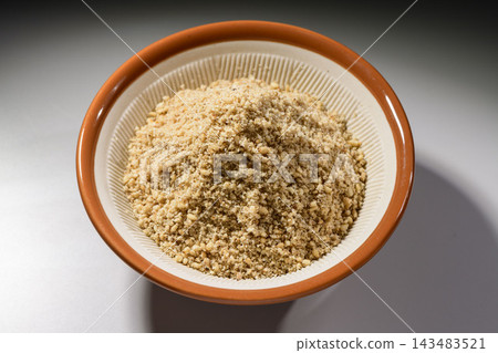 Close-up of white sesame powder in a mortar and pestle, a cooking ingredient. Close-up of white sesame powder in a mortar and pestle, a cooking ingredient. 143483521