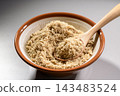 A cooking scene where ground sesame seeds in a mortar are stirred with a wooden spoon. 143483524