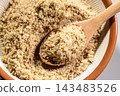A mortar and pestle, a utensil for grinding sesame seeds, and a wooden spoon holding white sesame powder. 143483526
