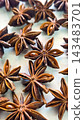 Rich, brown star anise pods photographed in macro detail, highlighting their star shapes, texture and glossy seeds 143483701