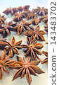 Rich, brown star anise pods photographed in macro detail, highlighting their star shapes, texture and glossy seeds 143483702