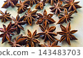 Rich, brown star anise pods photographed in macro detail, highlighting their star shapes, texture and glossy seeds 143483703